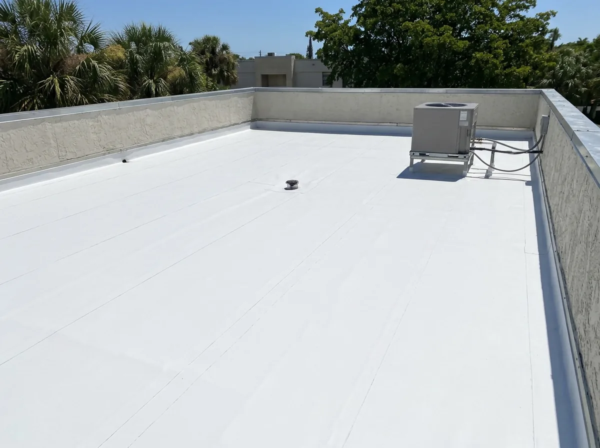 A white TPO membrane flat roof with welded seams and a parapet wall